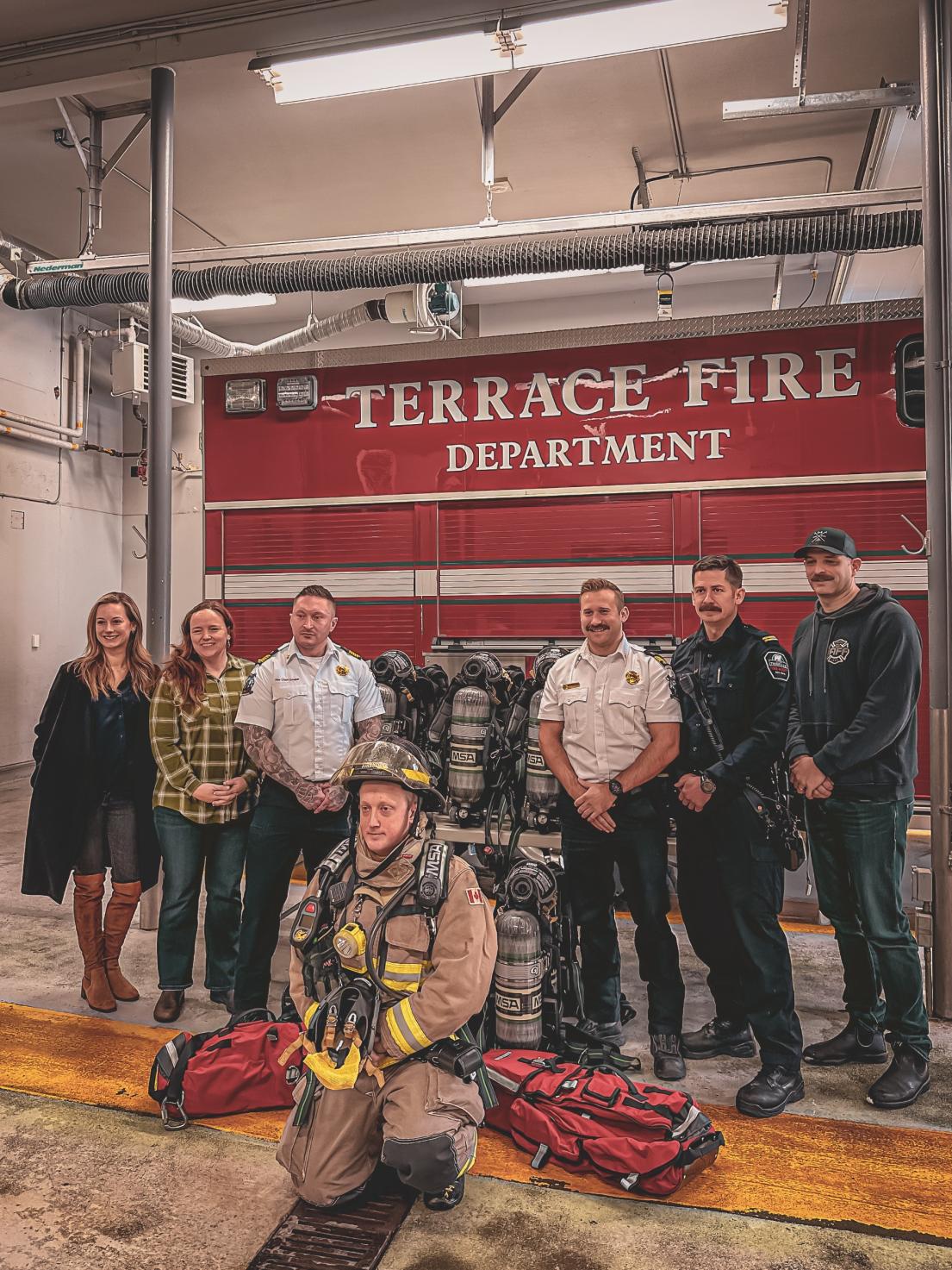 A group photo of fire department staff and others featuring new fire department equipment